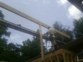 Carpenter setting a ridge beam over a new addition frame — Ice Dam Removal by Roofing Brothers in Tompkinsville