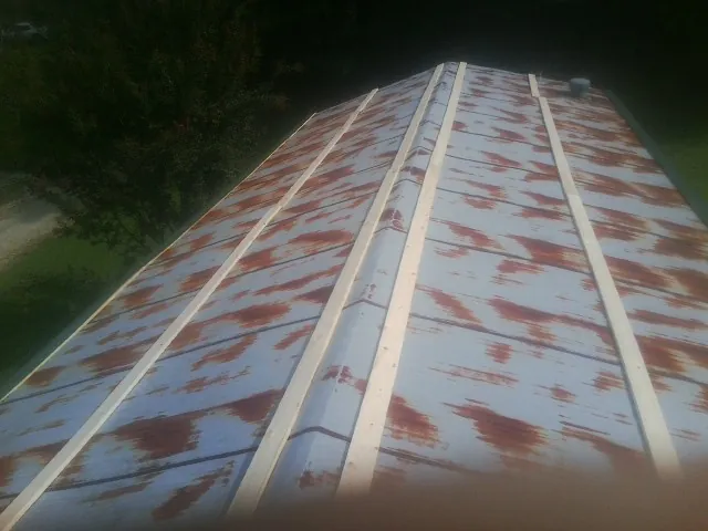 Rusted metal roof panels with new wood purlins before replacement — Storm Damage Roof Repair in Tompkinsville by Roofing Brothers