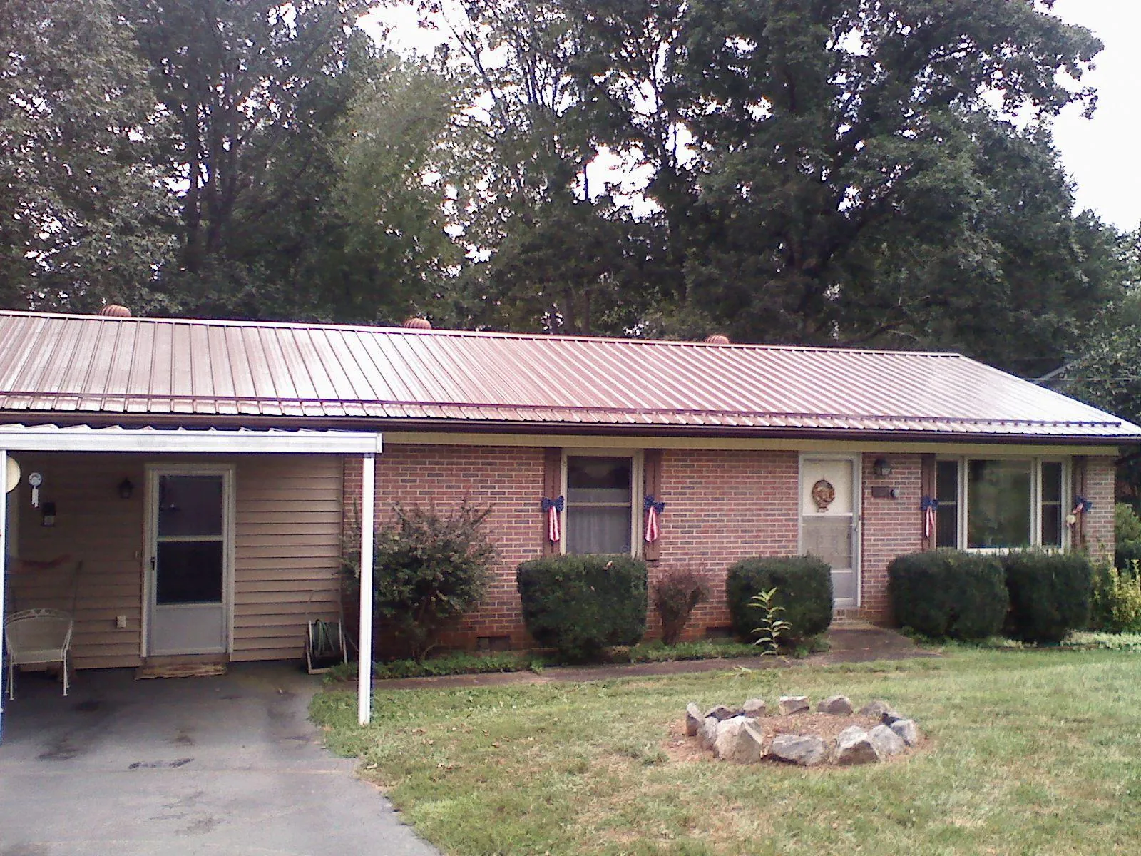 Bronze metal roof and carport on a brick ranch home — Roof Repair work by our crew in Tompkinsville