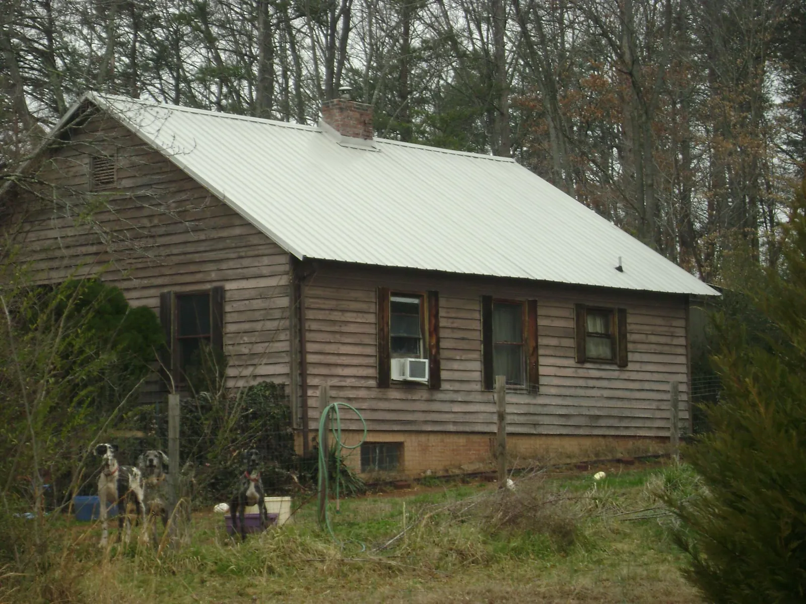 White metal roof on an old wood sided farmhouse, from a Metal Roof Installation job in Tompkinsville